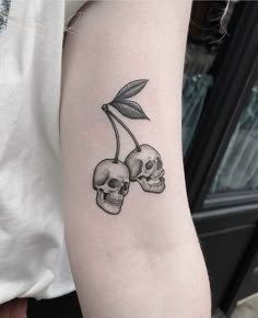 two skulls with leaves on the arm