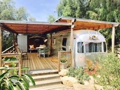 an airstream sits in the middle of a wooden deck