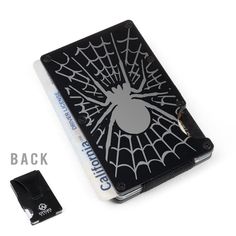 a black and white spider web notebook with clippings on the side, next to it's packaging