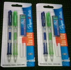 two green and blue pens sitting on top of each other in plastic packaging with white caps