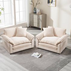 two chairs sitting on top of a rug in a living room next to each other