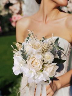 a bride holding a bouquet of white flowers