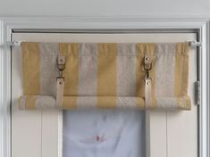 the curtain is hanging on the side of the door with two hooks attached to it