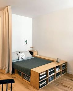 a bed sitting in the middle of a bedroom next to a wooden table and chair