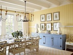 a dining room with yellow walls and blue furniture