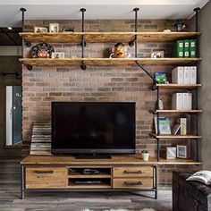 a living room with brick walls and shelves on the wall, including a flat screen tv