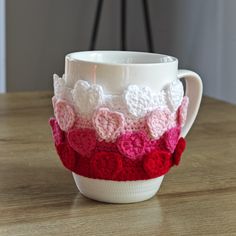 a coffee cup with crocheted flowers on it