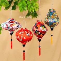 four chinese lanterns hanging from a tree