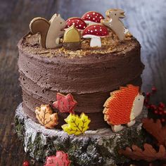 there is a chocolate cake decorated with animals and leaves on the top, along with other decorations