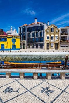 boats are docked in the water next to some buildings and cobblestone walkways