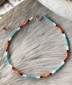 the multicolored beaded bracelet is sitting on top of a cowhide rug