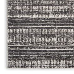 an area rug with grey and white stripes on the side, in front of a white background