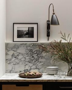 a marble counter top with plates and bowls on it