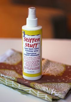 a bottle of stuff sitting on top of a table next to a napkin and cloth