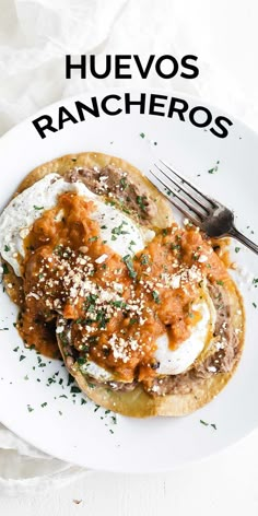 a white plate topped with an egg and meat enchilada next to a fork