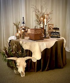 a table topped with a cow's skull and candles