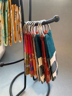 an ironing board holding several pairs of colorful scarves on it's hangers