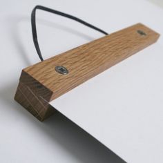 a piece of wood that is on top of a white paper with a black cord