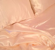 an unmade bed with white sheets and pillowcases on top of each other