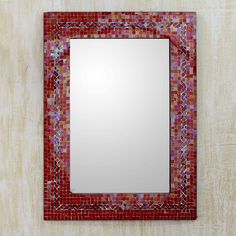 a red mosaic tile mirror mounted on a wall