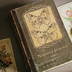 an old book sitting on top of a table next to some flowers and other items