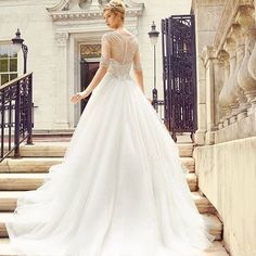 a woman in a wedding dress standing on some steps