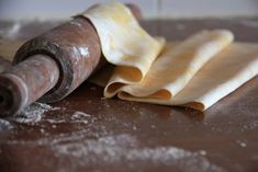 rolled up dough and rolling roller on top of a table