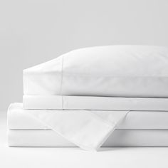 white sheets and pillowcases stacked on top of each other