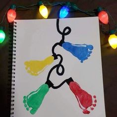 a hand and foot print on a sheet of paper with christmas lights in the background