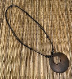 Discover the elegance of nature with our Brown Circle Pendant Necklace, a perfect blend of style and natural beauty. This unisex necklace features a meticulously crafted wooden pendant, showcasing a beautiful wood design that captures the essence of the earth's simplicity and grace. Pendant Specifications:     Size: 2.25 inches in diameter, offering a prominent yet comfortable size.     Material: High-quality wood, chosen for its durability and natural aesthetics. Necklace Features:     Adjustab Nature-inspired Brown Necklaces With Natural Variations, Nature-inspired Brown Necklace With Natural Variations, Adjustable Wood Jewelry Nature-inspired, Adjustable Wood Jewelry In Nature-inspired Style, Brown Wooden Beads Holistic Necklace, Holistic Brown Necklaces With Wooden Beads, Adjustable Nature-inspired Wooden Jewelry, Natural Wood Pendant Necklace, Adjustable Natural Wood Necklace Nature-inspired