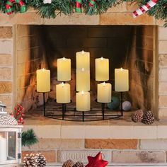 lit candles in front of a fireplace decorated for christmas