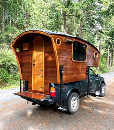 a truck with a wooden trailer attached to it's bed in front of some trees