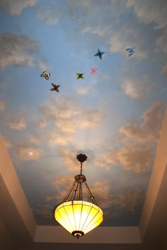 the ceiling is decorated with colorful birds flying in the sky, and there are two lamps on each side