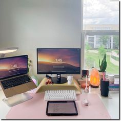 a laptop computer sitting on top of a desk next to a desktop computer monitor and keyboard