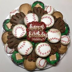 decorated cookies in the shape of baseballs and mitts are on a platter