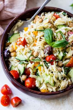 a bowl filled with rice, cucumbers and tomatoes