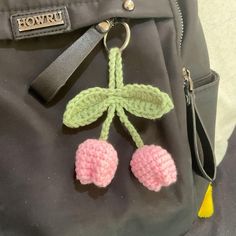 a crocheted cherry keychain hanging from a purse