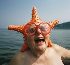 an older woman wearing glasses and a starfish hat on her head in the water