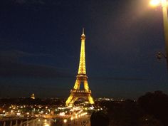 the eiffel tower is lit up at night