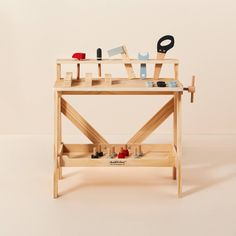 a wooden workbench with tools on the top and one drawer open to show items