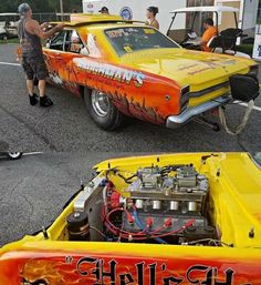 two men working on an orange and yellow car with flames painted on the hoods