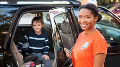 a woman standing next to a child in a car