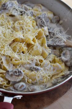 a pan filled with pasta and mushrooms covered in cheese