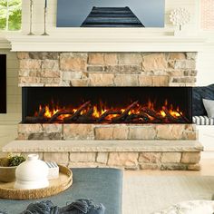 a living room with a stone fireplace and tv on the wall, in front of a couch