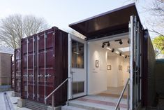 an open shipping container sitting on top of a cement floor next to a set of stairs