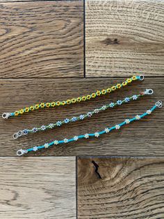 three different types of beaded lanyards on wood flooring with one being used as a keychain