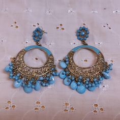 These beautiful pieces are Long Circular Goldtone Filigree Pierced Earrings Enhanced with Blue Enamel and Blue Stone Drops. The Stud is a Goldtone Circle Enhanced with Blue Stones with the longer Filigree section below. No maker's mark found. Used but in excellent condition. Dimensions are 3 inches by 2 inches. Blue Metal Chandelier Earrings With Dangling Beads, Blue Bohemian Metal Hoop Earrings, Blue Metal Chandelier Earrings For Pierced Ears, Blue Metal Dangle Hoop Earrings, Handmade Blue Costume Jewelry Earrings, Blue Metal Earrings With Dangling Beads, Blue Pierced Drop Chandelier Earrings, Handmade Blue Drop Earrings, Blue Bohemian Hoop Earrings For Pierced Ears