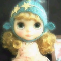 a close up of a doll wearing a hat and dress with stars on it's head