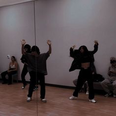 several people are dancing in a room with mirrors