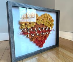 a heart made out of rolled flowers with the words grandad in red and yellow